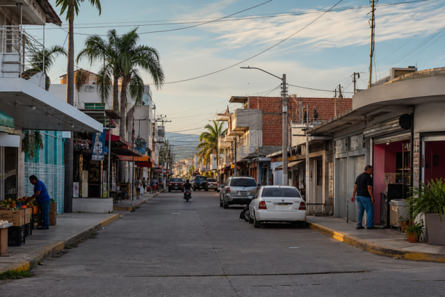 Calle comercial de Sinaloa con negocios abiertos y tránsito moderado, en una escena de economía local bajo vigilancia.