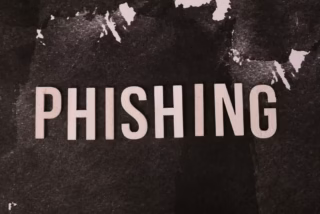 Mano sostiene un teléfono con un mensaje de alerta genérico en pantalla; recurso ilustrativo sobre prevención de phishing, sin mostrar una institución real.