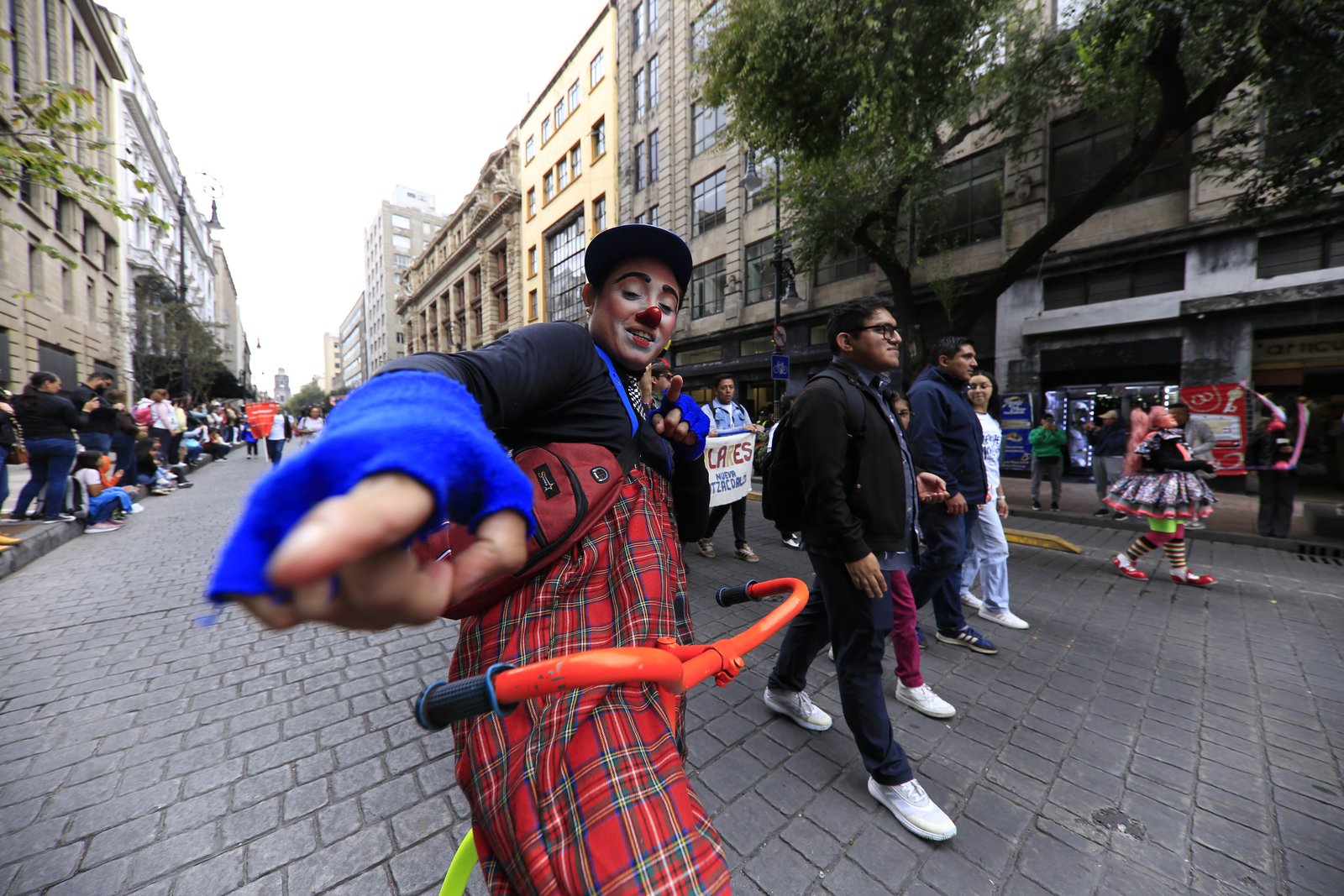Payaso saluda al público en una calle peatonal del Centro Histórico durante el Desfile de Alebrijes Monumentales 2026