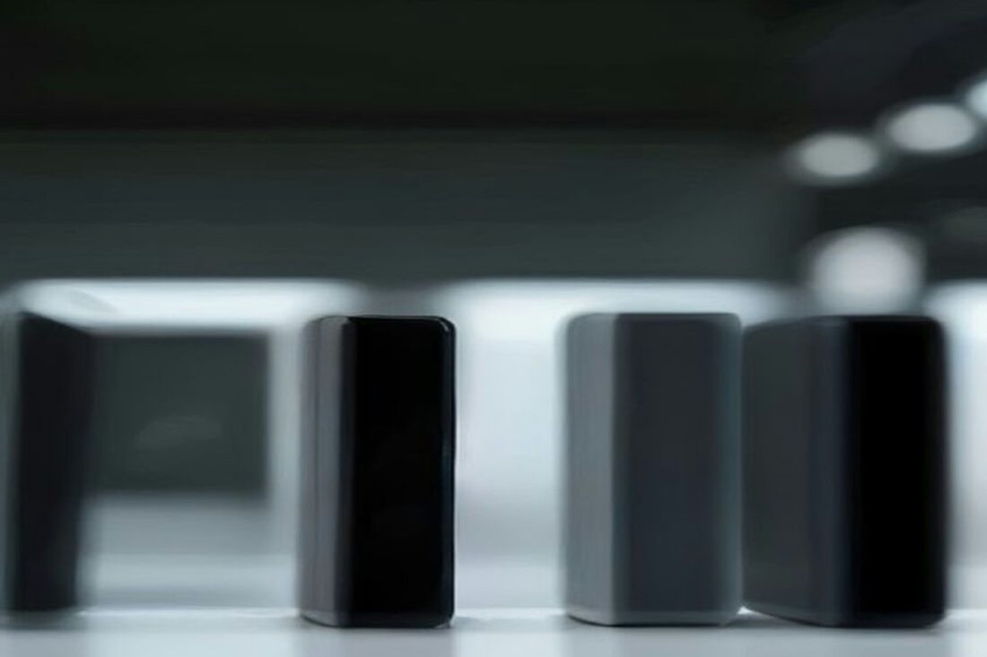 Varios dispositivos oscuros alineados sobre una mesa blanca de exhibición en una tienda iluminada