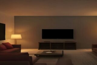 Sala de estar de noche con sillones rojos, lámparas encendidas y una pantalla plana apagada en la pared, alusiva a los estrenos de Netflix de noviembre de 2026