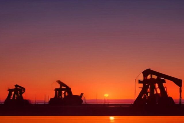 Siluetas de bombas extractoras de petróleo en un campo petrolero al atardecer con cielo naranja y morado, sin personas ni texto