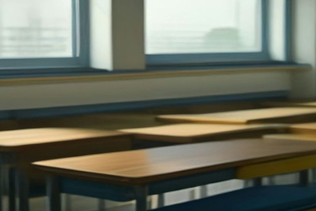 Salón de clases vacío con pupitres de madera alineados junto a ventanas con luz suave de la mañana, alusivo al registro de la Beca Rita Cetina