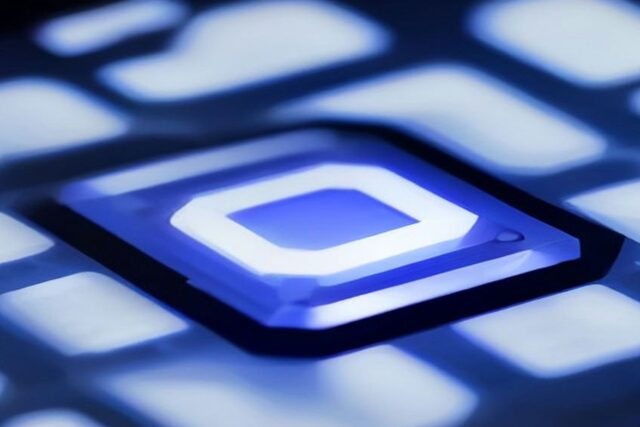 Primer plano de un componente electrónico iluminado en azul sobre una superficie tecnológica, en alusión a la industria de semiconductores